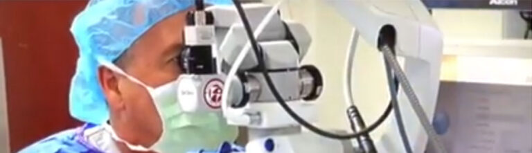 Surgeon using machine for eye surgery.