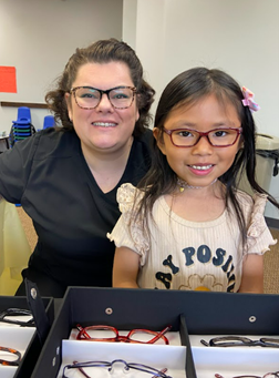 Doctor and child in glasses smiling at the camera