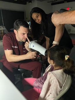 doctor performing an eye exam on a child